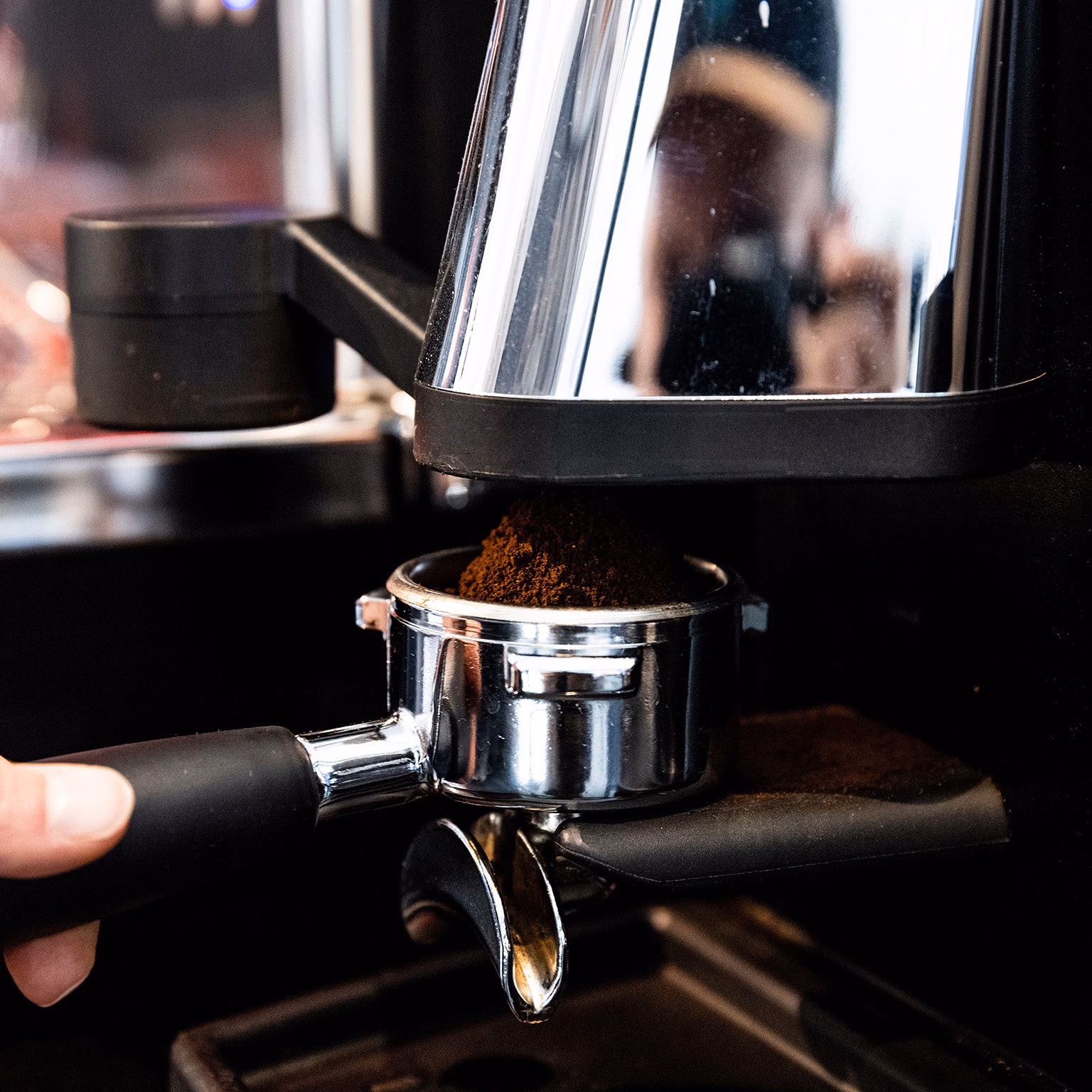 Siebträger, der aus einer Kaffeemühle Kaffee zieht