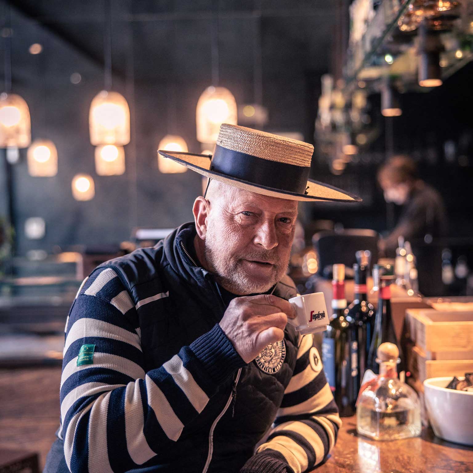 Mann mit Strohhut beim Kaffeetrinken